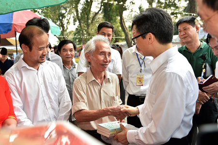 Phó Thủ tướng Vũ Đức Đam tặng sách cho bác Nguyễn Hải Đăng (một độc giả cao tuổi Thủ đô). -st-